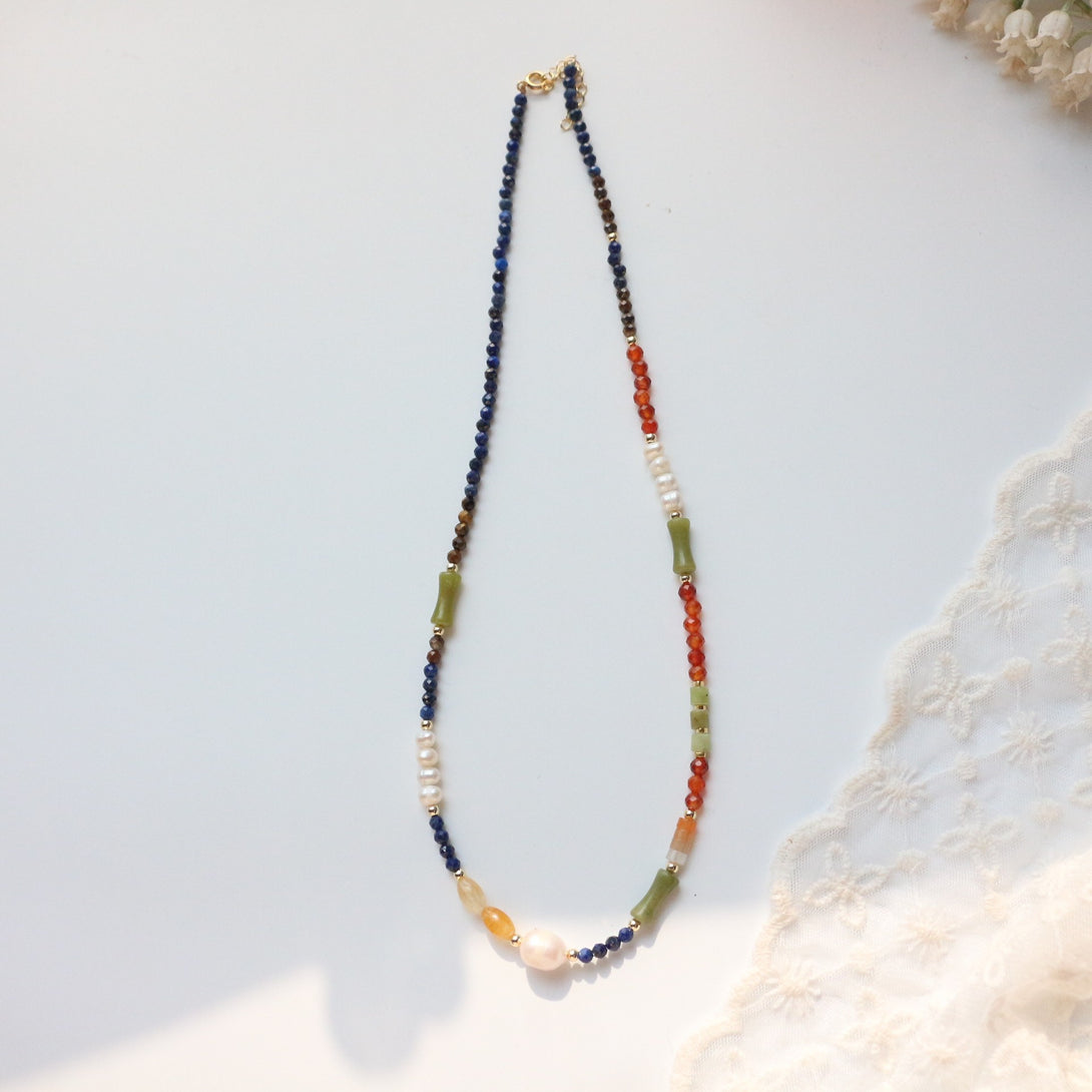 Image of the Vibrant Balance - Citrine Lapis Agate Necklace, featuring citrine, lapis lazuli, tiger's eye, red-orange agate, New Jade, and Baroque pearls with 18K gold-plated accents.