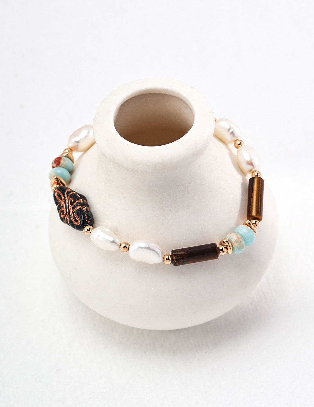 A vintage-inspired bracelet featuring Shoushan stone, tiger eye beads, and freshwater pearls.