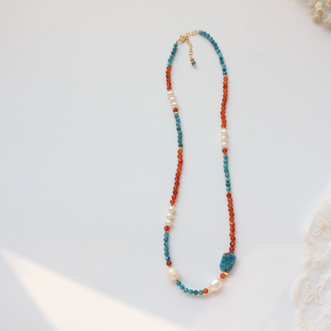 Azure Flame Necklace featuring blue apatite, red-orange agate, and Baroque pearls with 18k gold-plated details.