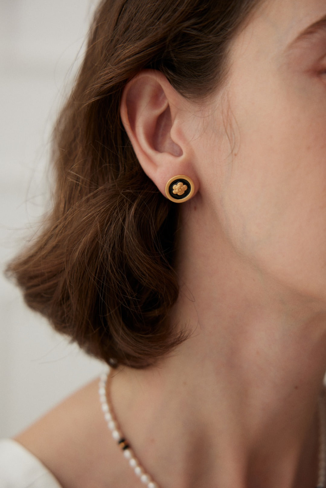 Noir Blossom Studs featuring 18ct gold vermeil with a vintage gold finish and black enamel floral design, offering elegance and sophistication.
